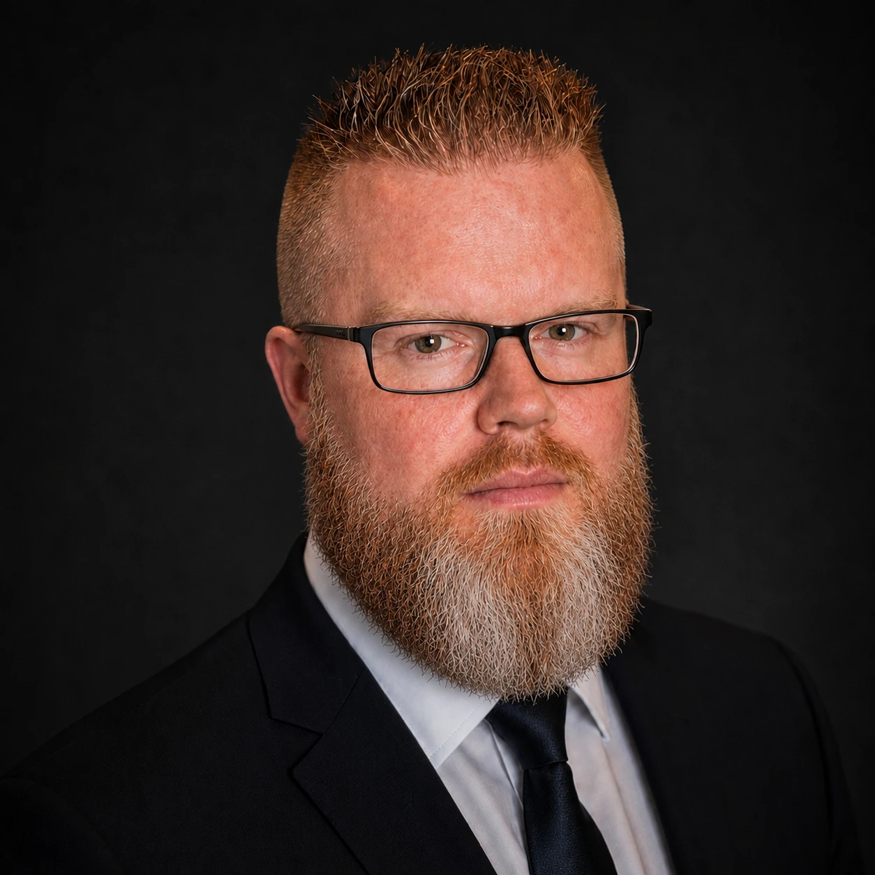 Joshua H. White in a dark suit and glasses